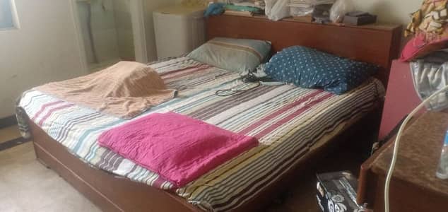 Old double bed with mattress and side tables