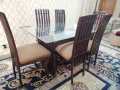 Glass dinning table for sale with 6 wooden chairs