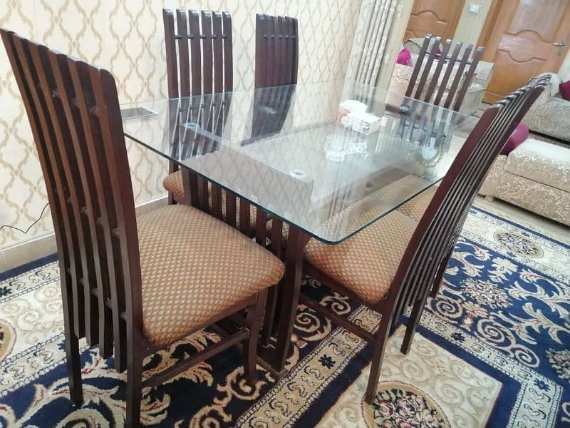 Glass dinning table for sale with 6 wooden chairs 1