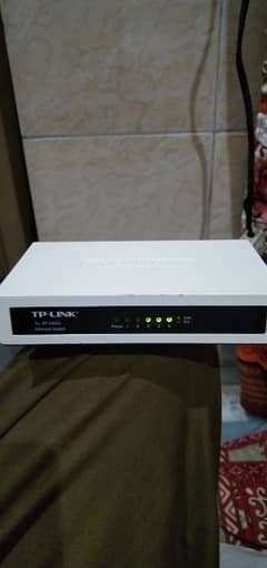 TP-Link 5 port switch device with adapter.