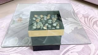 Coffee table having 2 ft square glass top with decorative stones init 0