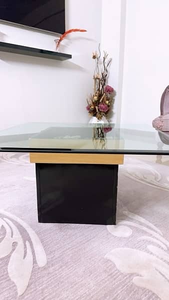 Coffee table having 2 ft square glass top with decorative stones init 1