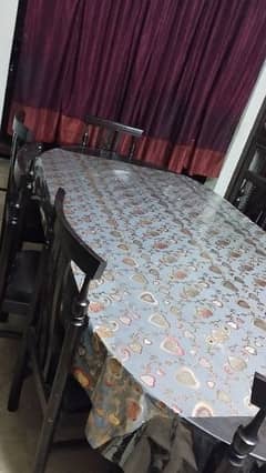 a wooden dinning table with 8 chairs in good condition