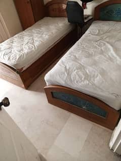 two single sized beds with storage drawers and mattress