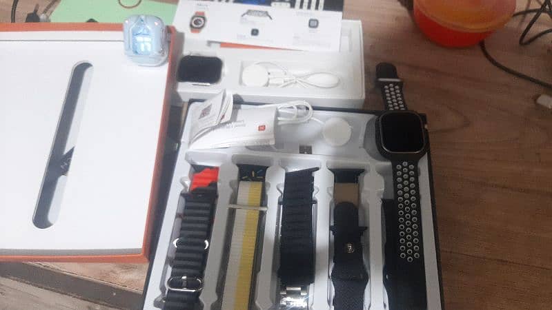 2 Apple watch ultra, ultra2 with cover and earbuds 3