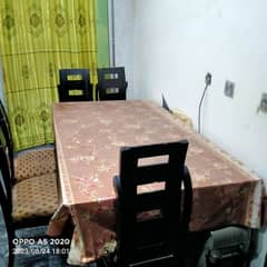 A Dining Table with 5 Chairs for siting in a very neat condition