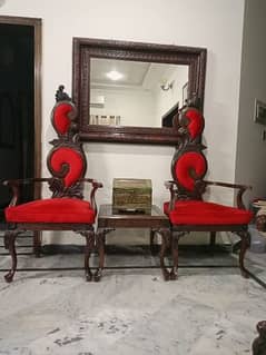 2 Red Decorative chairs, made from solid chinyoti wood, with a table.