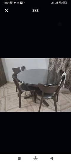 Round dining table with three chairs for sale.