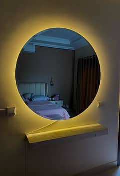round mirror with lights along with a dressing stand