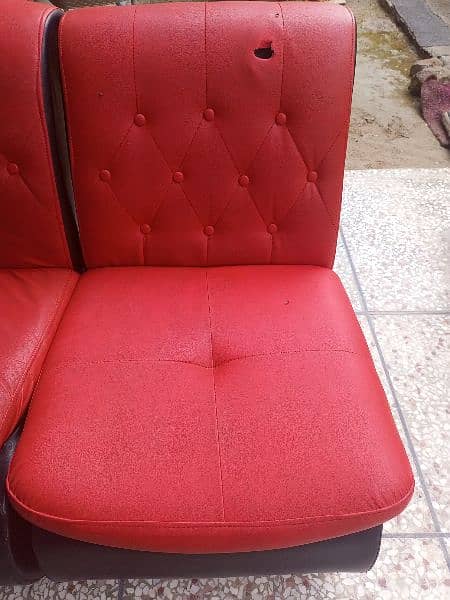 Used sofa in red and black color. Leather polish. 1