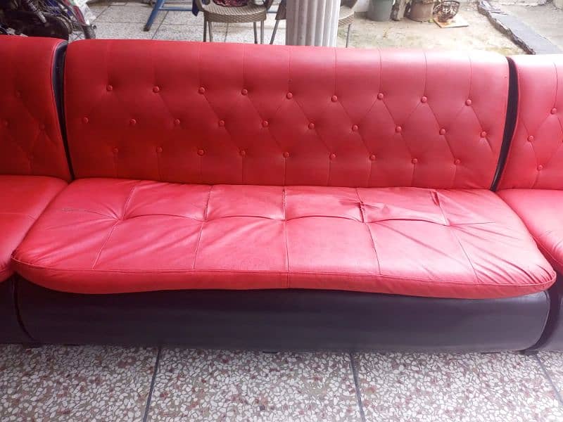 Used sofa in red and black color. Leather polish. 2