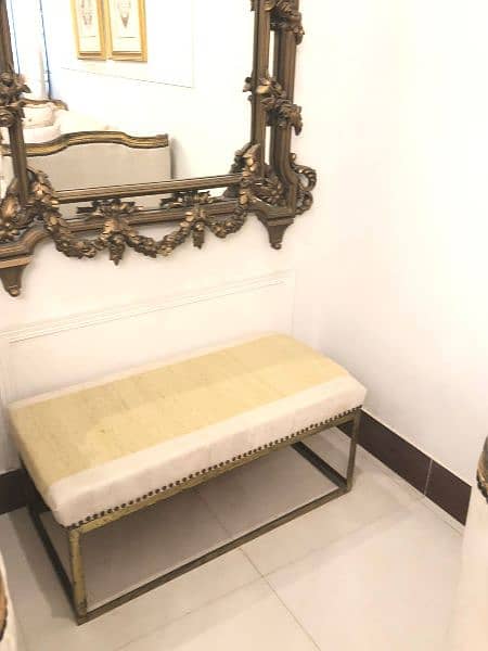 golden brass mirror and beige and golden cushioned seats 9