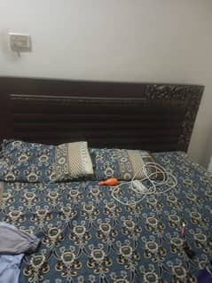 double bed without mattress and one dressing table with mirror