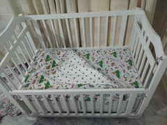 white color crib with mattress and bedsheets