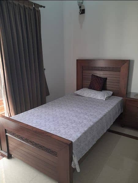 2 wooden single beds with 1 side table 1