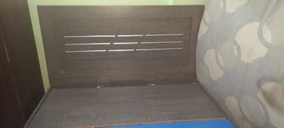 lightly used wooden bed with mattress