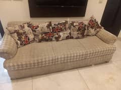 gray white sofa with UK flag print cushions, I