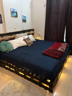 king size bed with queen size mattress and rope lights with side lamp
