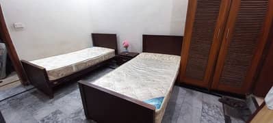 Single beds with spring mattresses and side table.