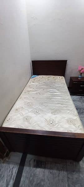 Single beds with spring mattresses and side table. 4
