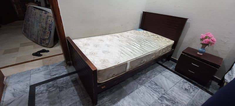 Single beds with spring mattresses and side table. 7