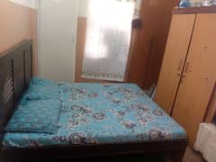 double bed with mattress and two-door cupboard
