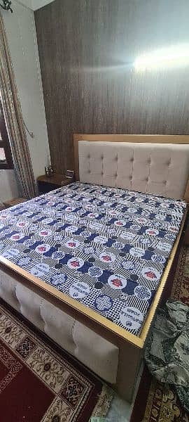 king size wooden bed with 2 side tables and bedroom couch. 0