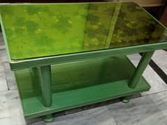 Plastic table with glass top for sale.