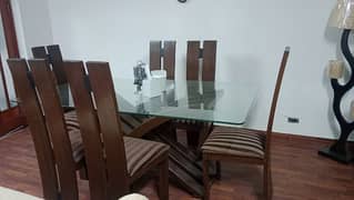 six chairs dining table with glass on top of the table