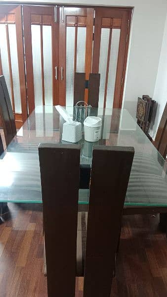 six chairs dining table with glass on top of the table 1