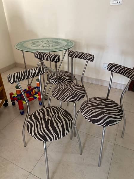 modern dinning ; iron stand with glass table and four chairs for sale 1