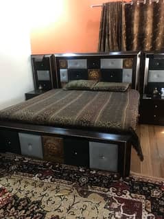 wooden double bed with side tables and spring mattress