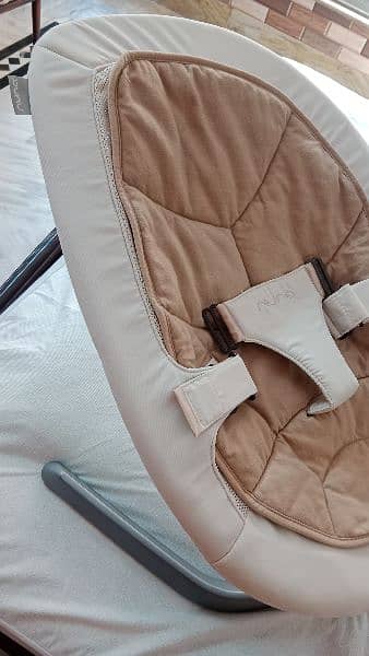 Nuna rocking baby chair for newborns, moving, and still lock options. 2
