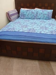 wooden bed with side table
