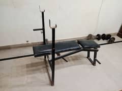 gym bench press and plates and dumbbells and rod