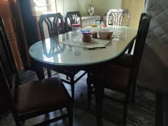 dinning table with 6 chairs a glass on the table