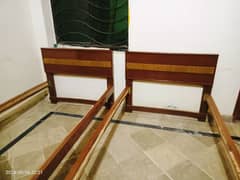 2 wooden single beds