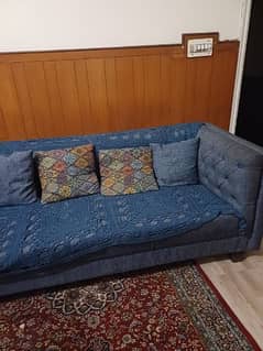 five seater sofa grey blue color and brown curtains
