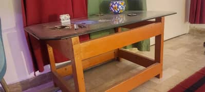 Wooden table with thick glass top