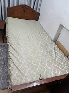2 brown wooden beds with mattresses