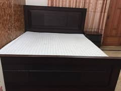 Wooden bed (king size) with side tables.