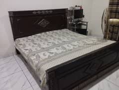 wooden bed with mattress