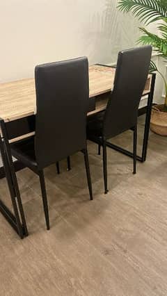 White table with 4 black chairs