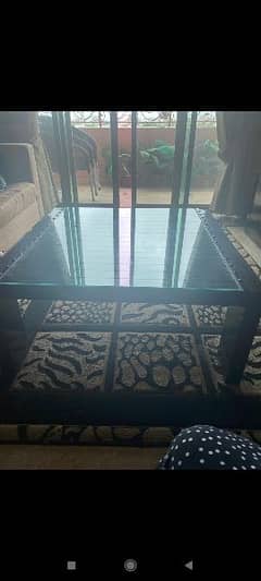 Dark brown wooden center table with glass top