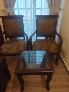 Two room chairs with a center table is available for sale