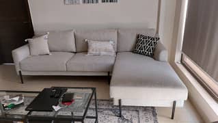 An L shaped off white sofa with metallic legs