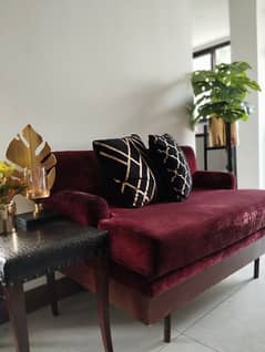 maroon 2 seater vintaged sofa with black patterned cushions
