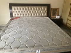 double bed with mattress and two side tables and dressing table