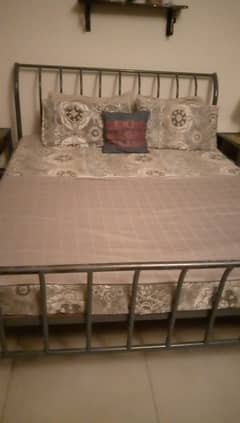 Wrought iron bed with 2 side tables and mattress.