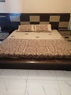 king size bed with 2 side tables and a dressing table
